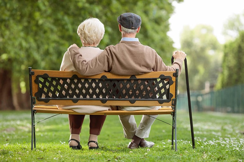 24-Stunden Pflege Steiermark, älteres Paar sitzt auf Parkbank und genießt das Leben, Aufnahme im Freien
